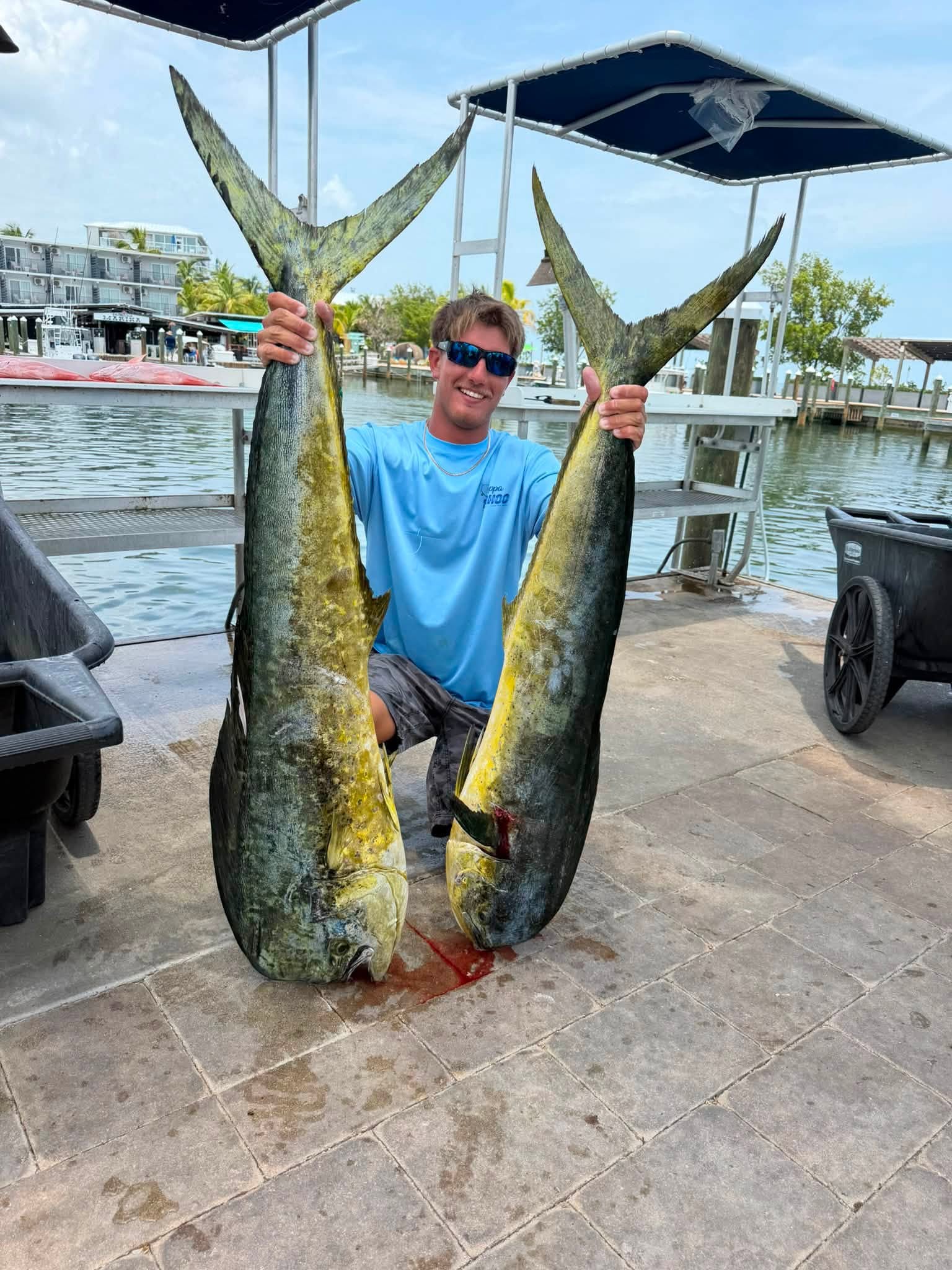 A pair of bull mahi held high at the dock