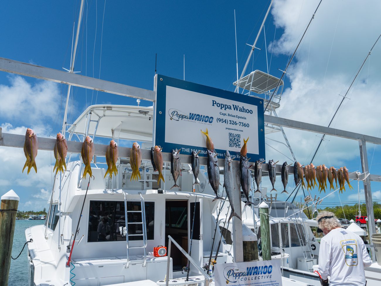 A Poppa Wahoo Collective boat at the dock under a full catch board