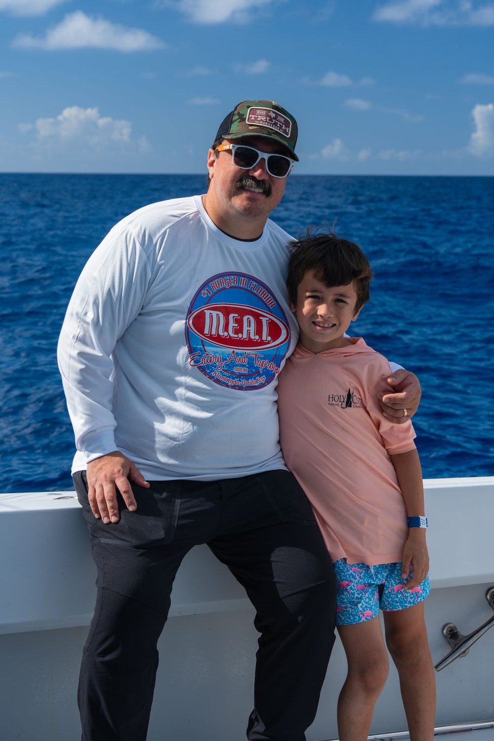 A father and son aboard a Poppa Wahoo Collective charter