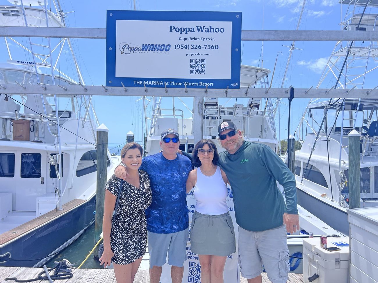 Family and friends at the Poppa Wahoo sign at Three Waters Resort Marina