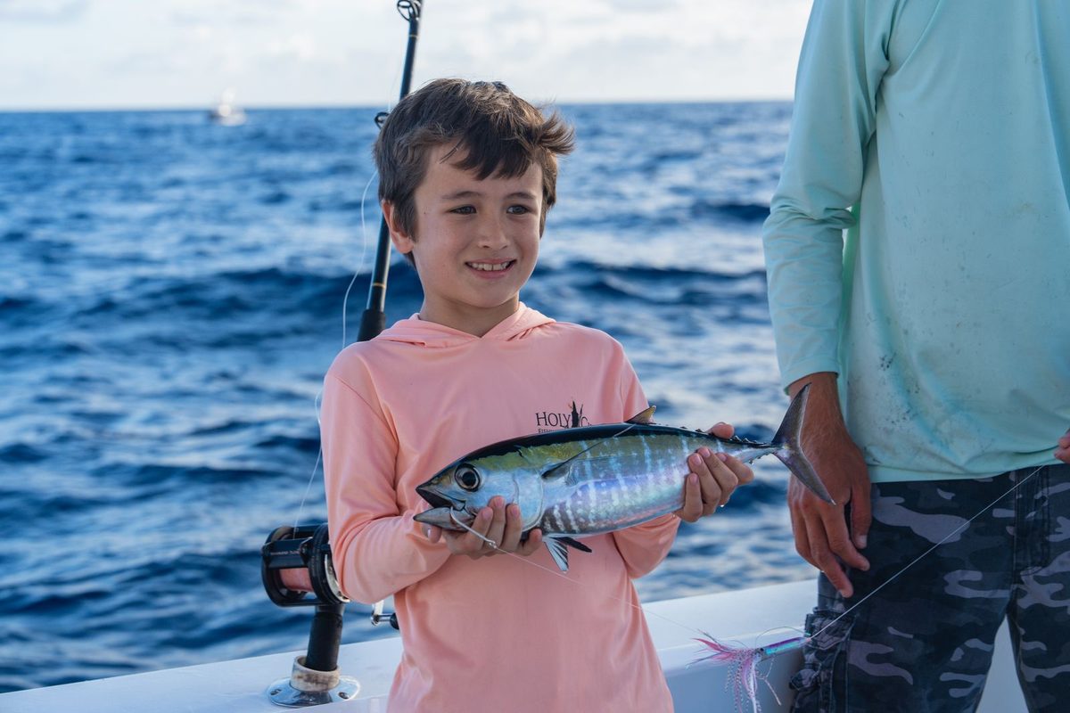 A young angler with his catch aboard a Poppa Wahoo Collective boat