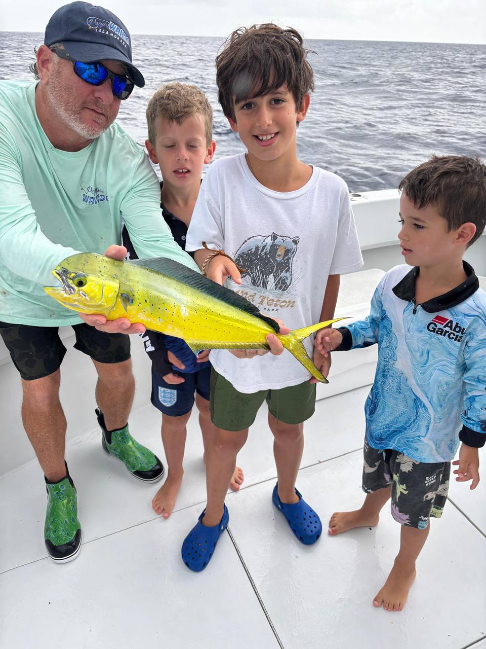 A captain and three young anglers with a mahi mahi off Islamorada