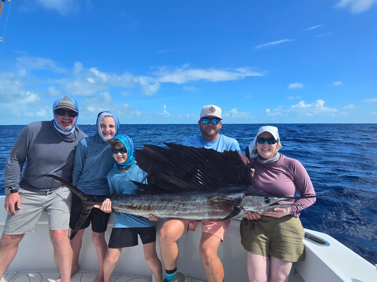 A family with a sailfish across their laps before release